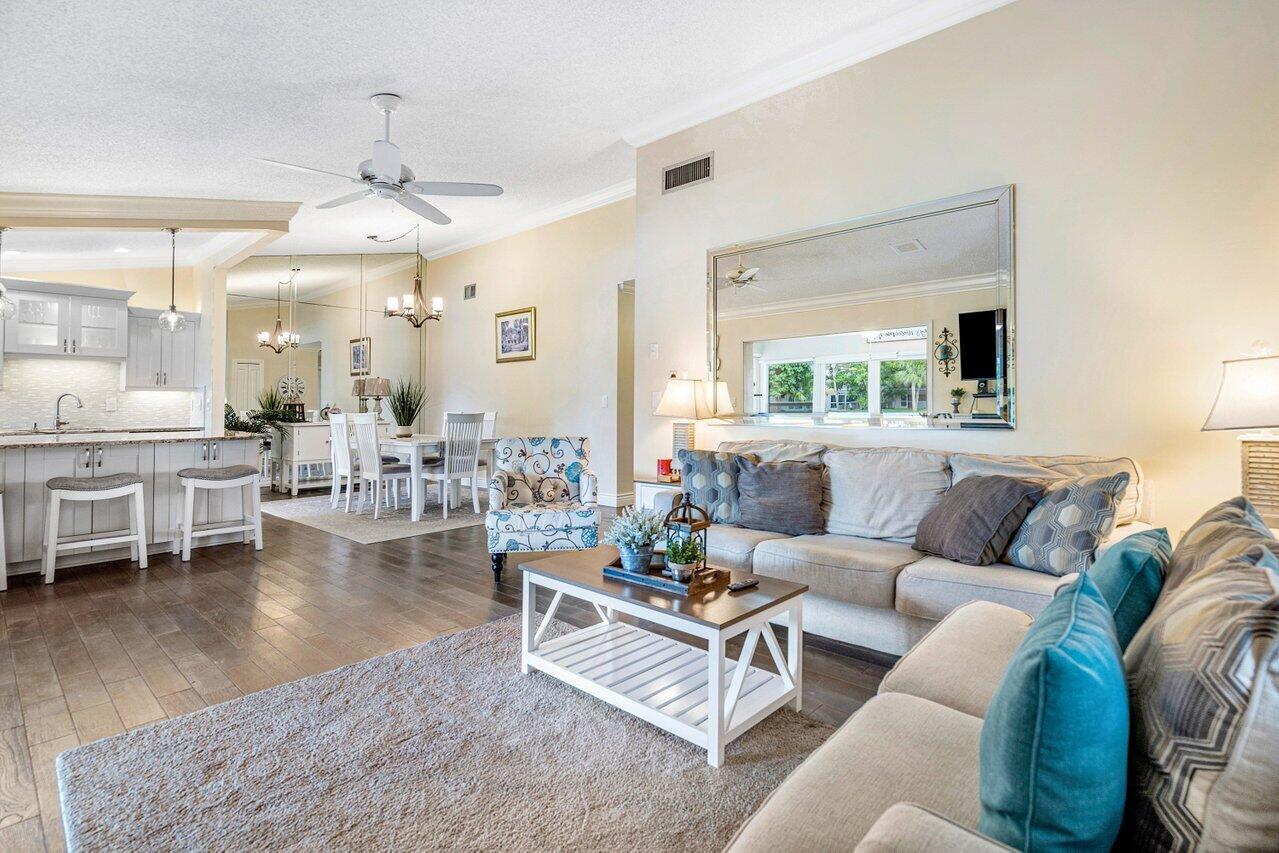 844 Lago Road Delray Beach, FL 33445 - Photo 17 of 43 a living room with furniture wooden floor and a chandelier