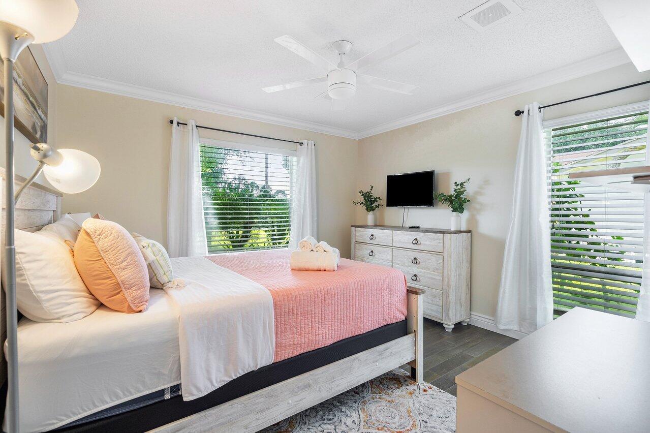 844 Lago Road Delray Beach, FL 33445 - Photo 25 of 43 a bedroom with a bed and a flat tv screen on dresser