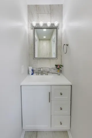 a bathroom with a sink vanity and mirror