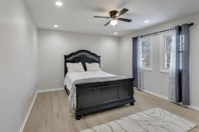 a bed room with a bed and a ceiling fan