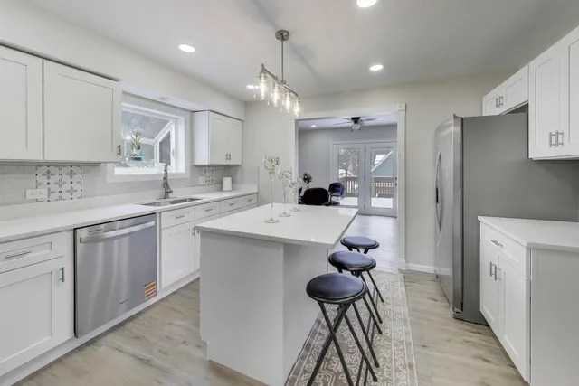 a kitchen with kitchen island a sink stainless steel appliances and cabinets