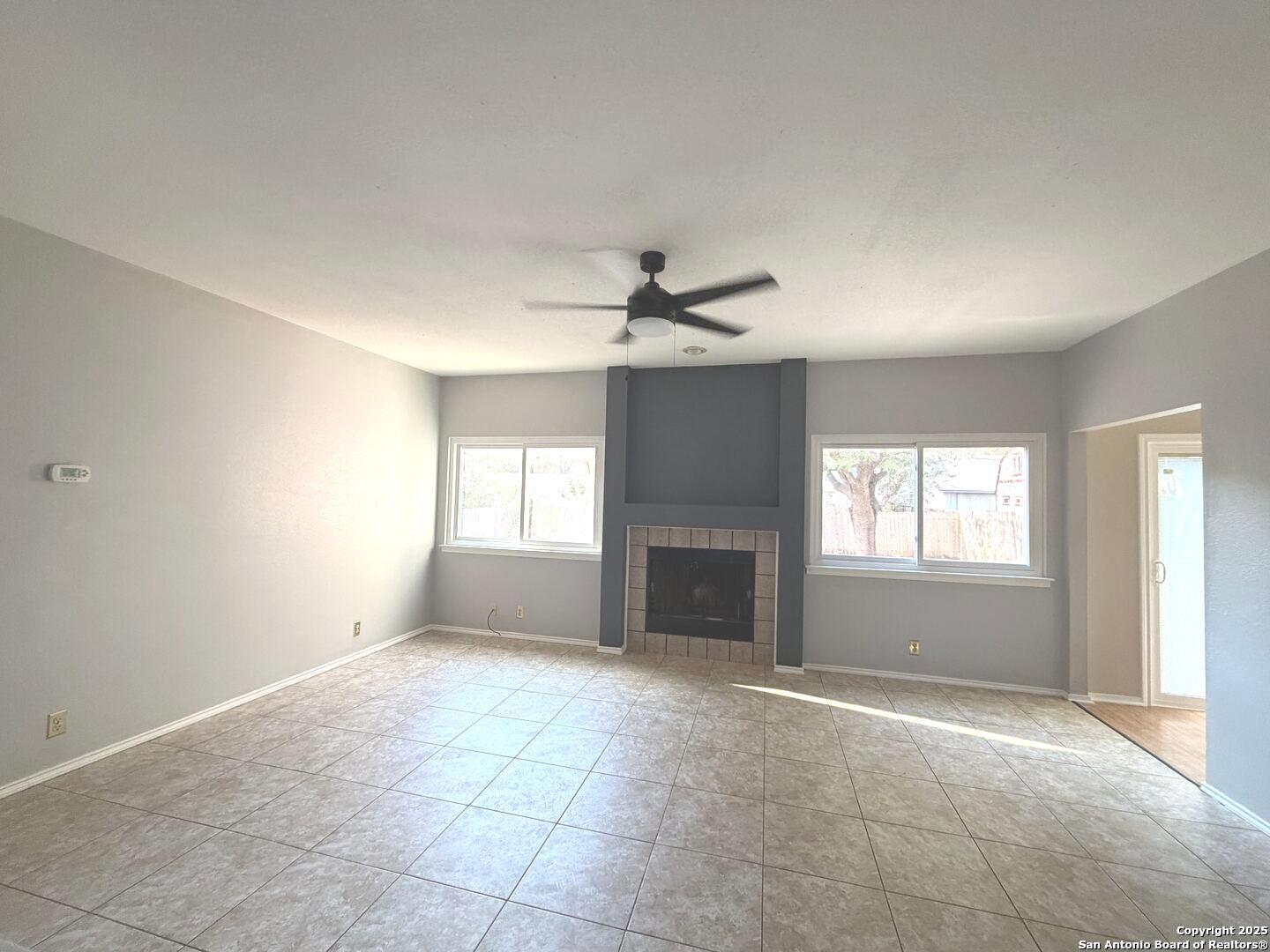 5955 Spring Crossing San Antonio, TX 78247 - Photo 4 of 17 an empty room with windows and fireplace