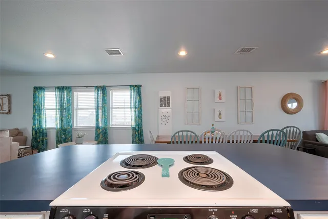 a kitchen with kitchen island stainless steel appliances granite countertop a sink and a stove