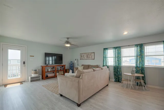 a living room with furniture a flat screen tv and a large window
