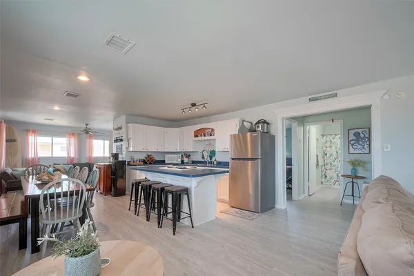 a kitchen with stainless steel appliances kitchen island granite countertop a table and chairs in it