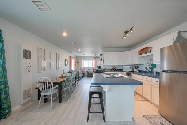 a kitchen with a table chairs refrigerator and cabinets