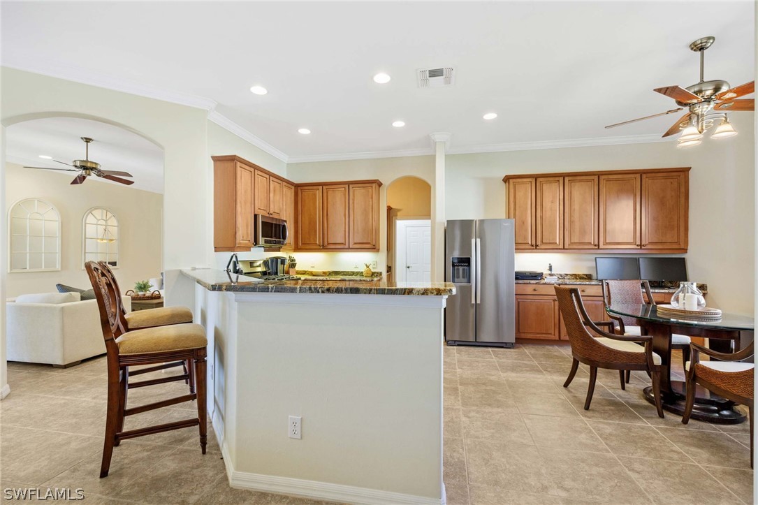 12934 Timber Ridge Drive Fort Myers, FL 33913 - Photo 8 of 24 a kitchen with refrigerator and chairs