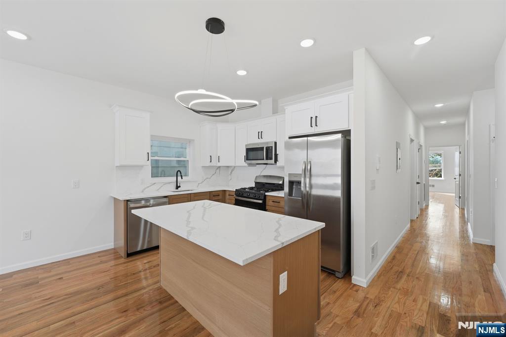 68 Sherman Avenue Newark, NJ 07114 - Photo 11 of 37 a kitchen with a refrigerator a sink and dishwasher with wooden floor