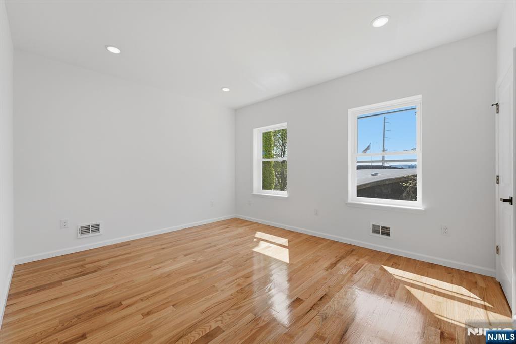 68 Sherman Avenue Newark, NJ 07114 - Photo 17 of 37 a view of an empty room with wooden floor and a window