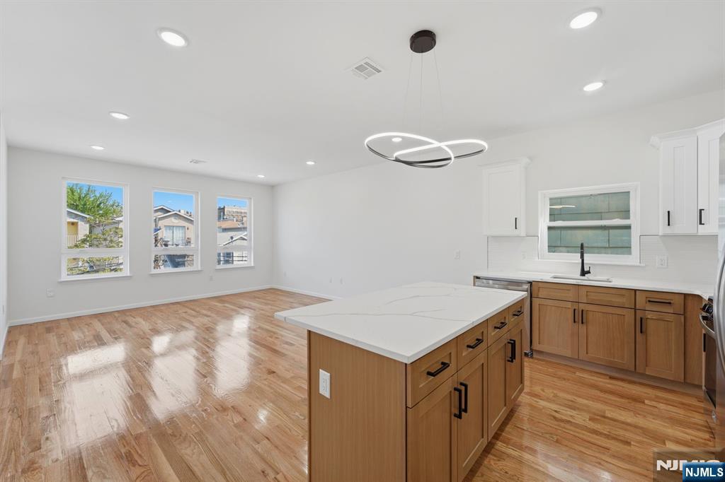 68 Sherman Avenue Newark, NJ 07114 - Photo 21 of 37 a kitchen with a stove a sink a microwave a center island and furniture