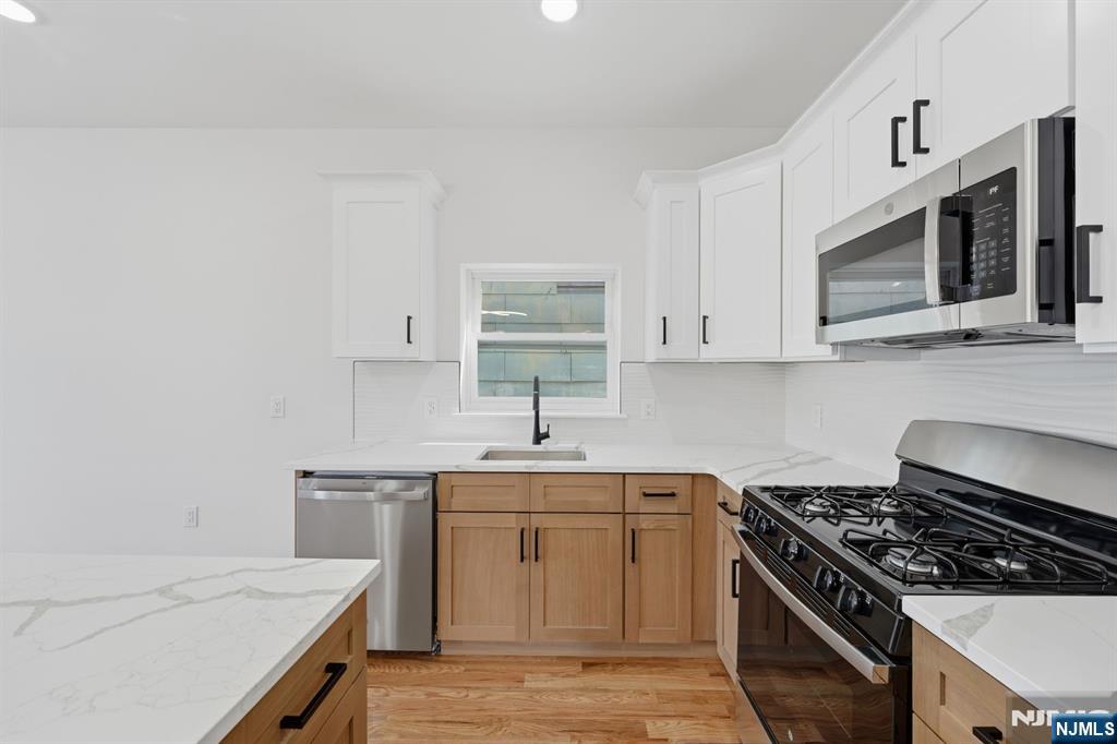 68 Sherman Avenue Newark, NJ 07114 - Photo 22 of 37 a kitchen with stainless steel appliances a sink stove and cabinets