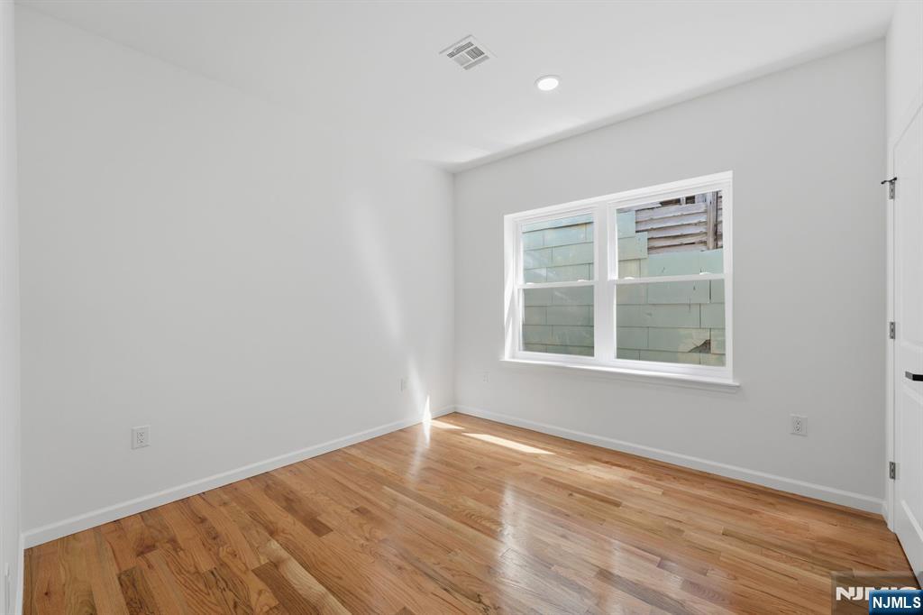 68 Sherman Avenue Newark, NJ 07114 - Photo 28 of 37 an empty room with wooden floor and windows