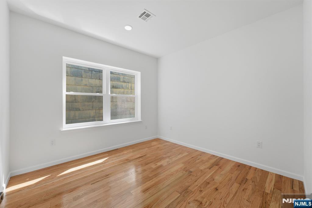 68 Sherman Avenue Newark, NJ 07114 - Photo 31 of 37 an empty room with wooden floor and windows