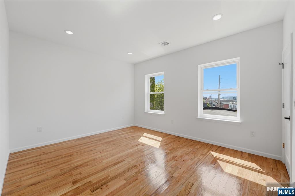 68 Sherman Avenue Newark, NJ 07114 - Photo 33 of 37 a view of an empty room with wooden floor and a window