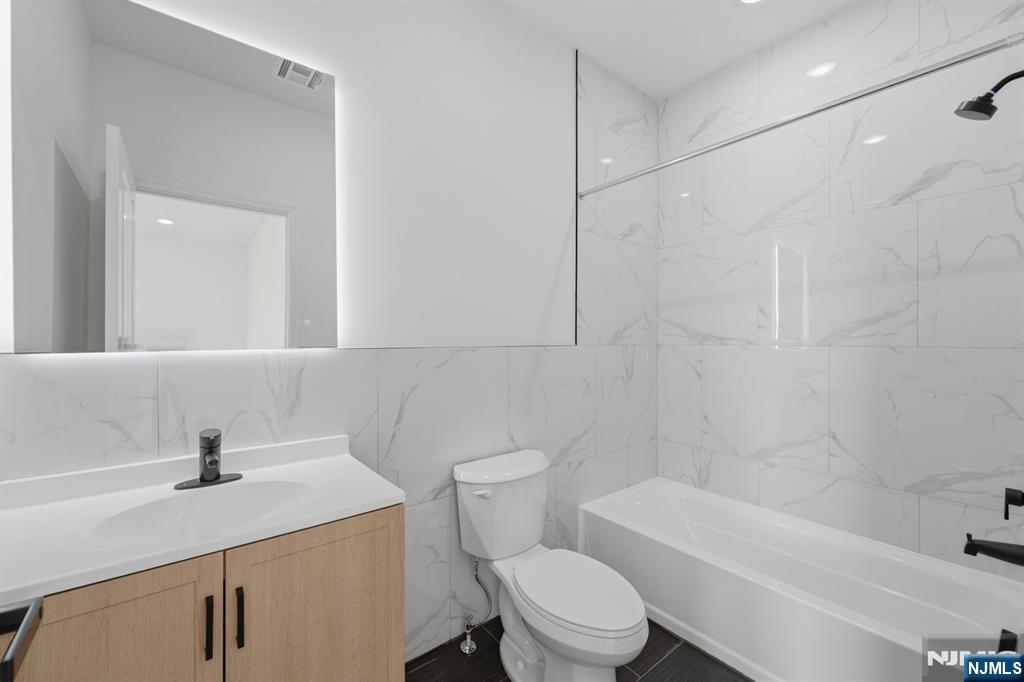 68 Sherman Avenue Newark, NJ 07114 - Photo 35 of 37 a bathroom with a sink a toilet and shower