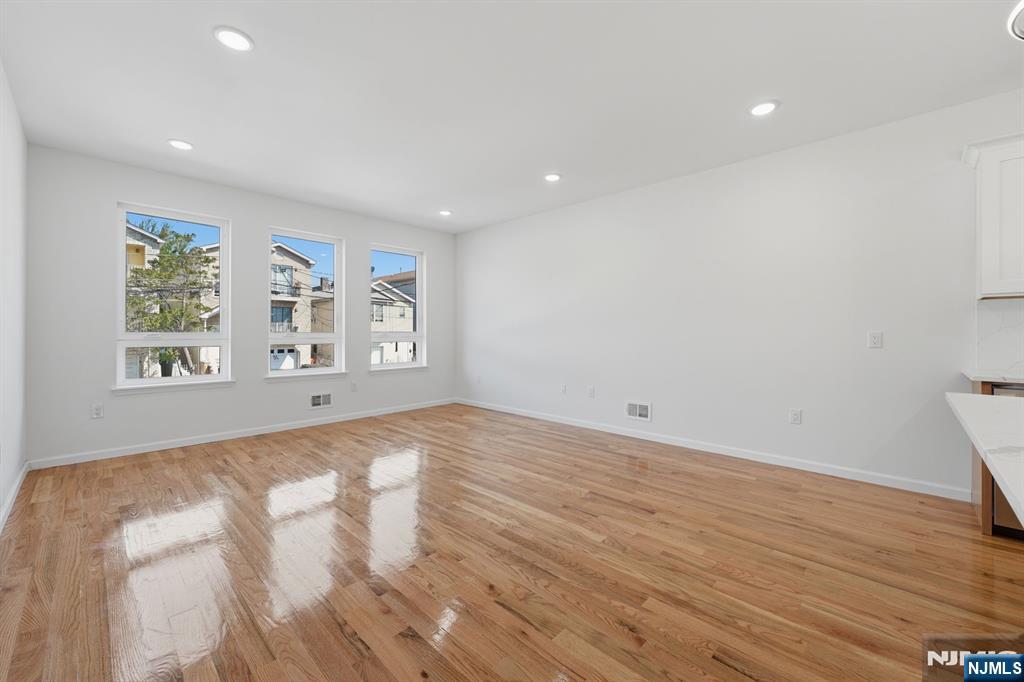 68 Sherman Avenue Newark, NJ 07114 - Photo 4 of 37 a view of an empty room with wooden floor and a window