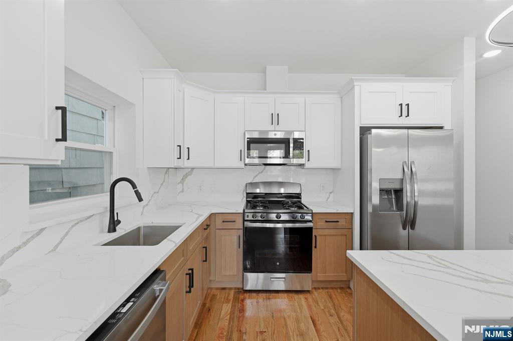 68 Sherman Avenue Newark, NJ 07114 - Photo 7 of 37 a kitchen with kitchen island stainless steel appliances a sink stove and refrigerator