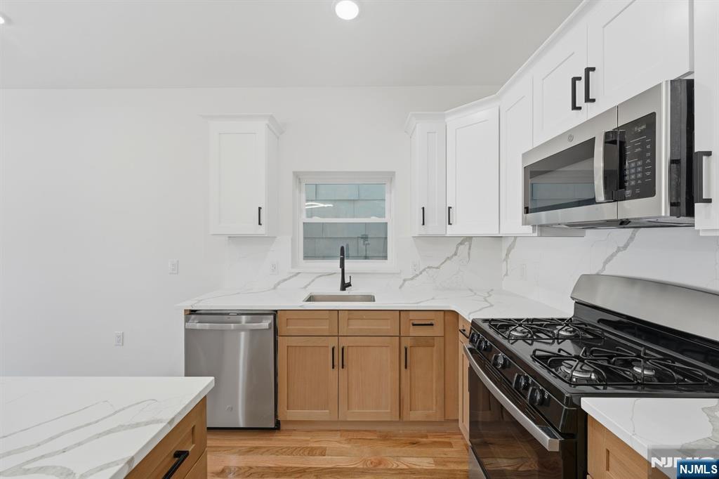 68 Sherman Avenue Newark, NJ 07114 - Photo 9 of 37 a kitchen with stainless steel appliances a sink stove and microwave