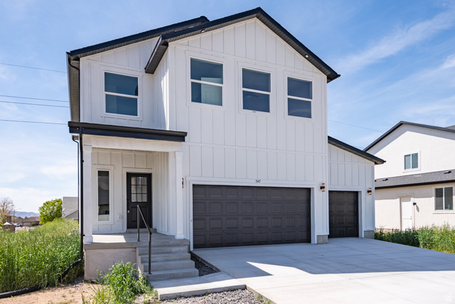 547 North Hvn Drive Mapleton, UT 84664 - Photo 3 of 23 Modern farmhouse exterior featuring white vertical board and batten siding, dark trim, and a covered porch entry