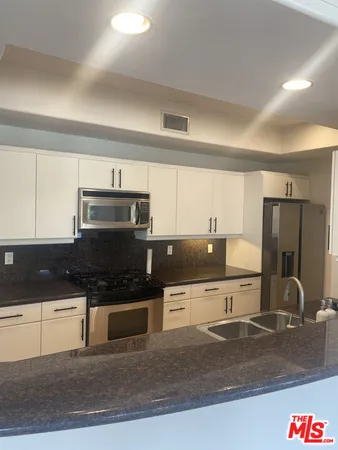 a kitchen with stainless steel appliances granite countertop a sink and cabinets