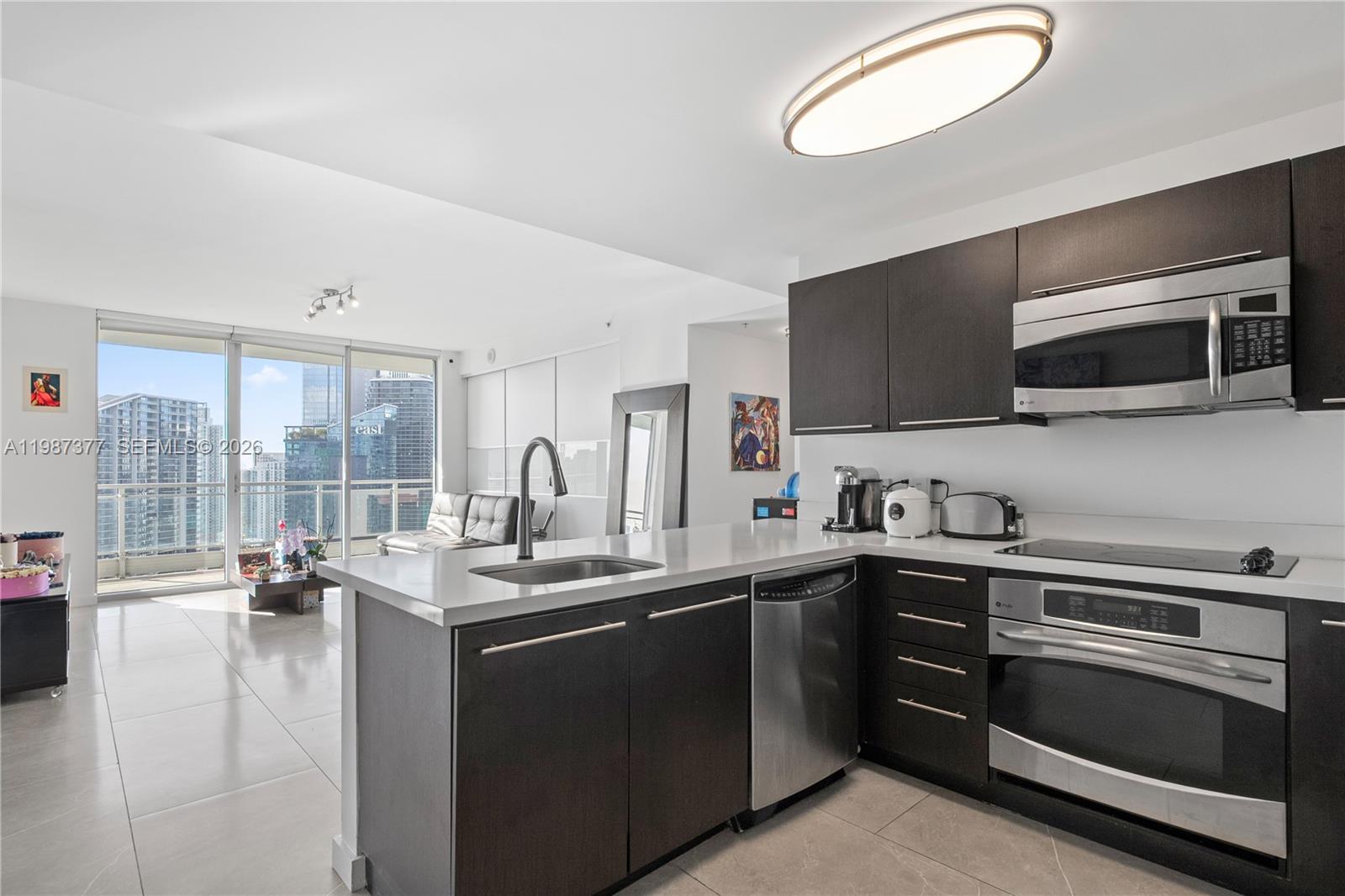 90 Southwest 3rd Street, Unit 4301 Miami, FL 33130 - Photo 6 of 18 a kitchen with a sink stove and microwave