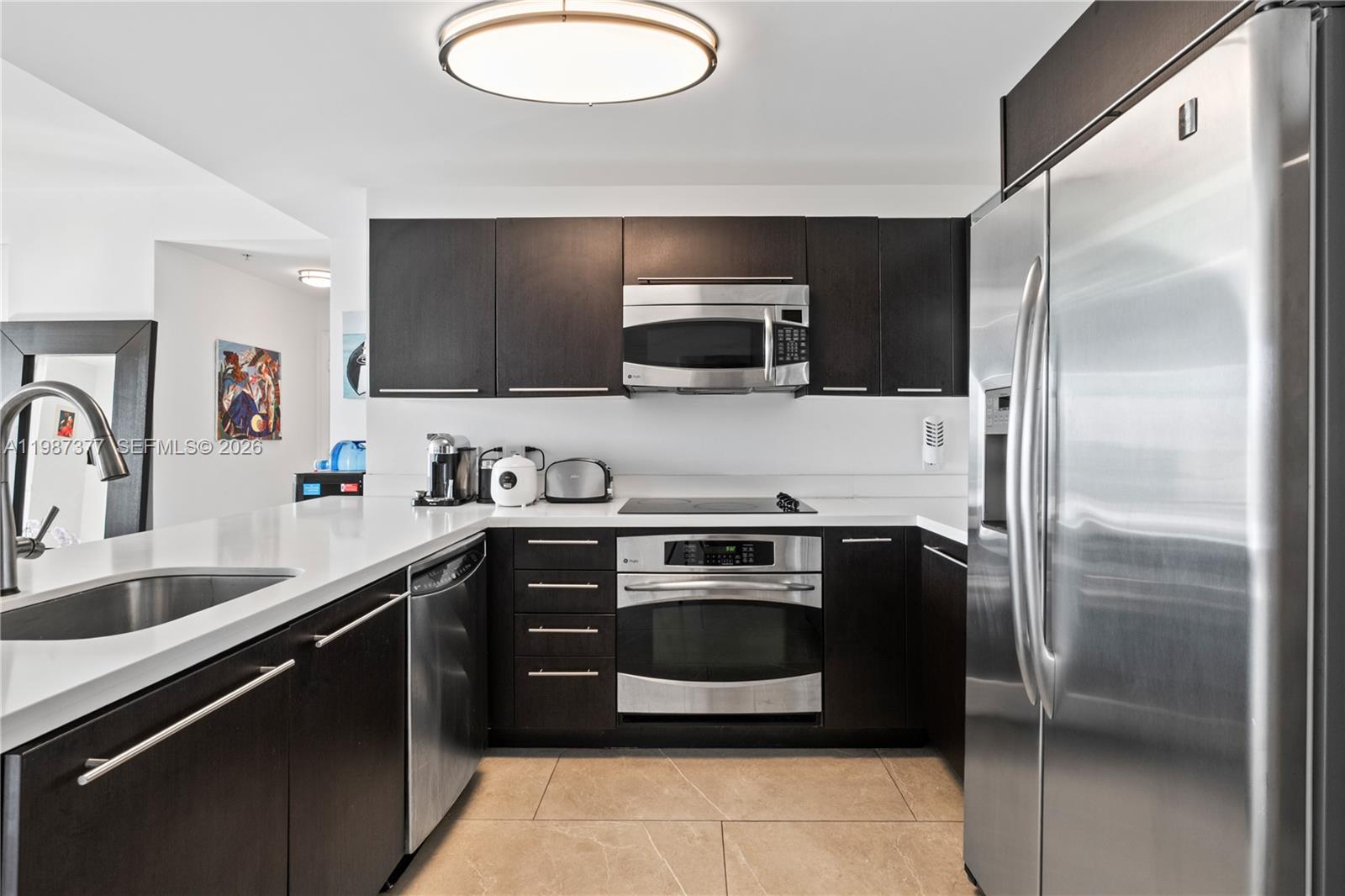 90 Southwest 3rd Street, Unit 4301 Miami, FL 33130 - Photo 7 of 18 a kitchen with stainless steel appliances granite countertop a sink and a refrigerator