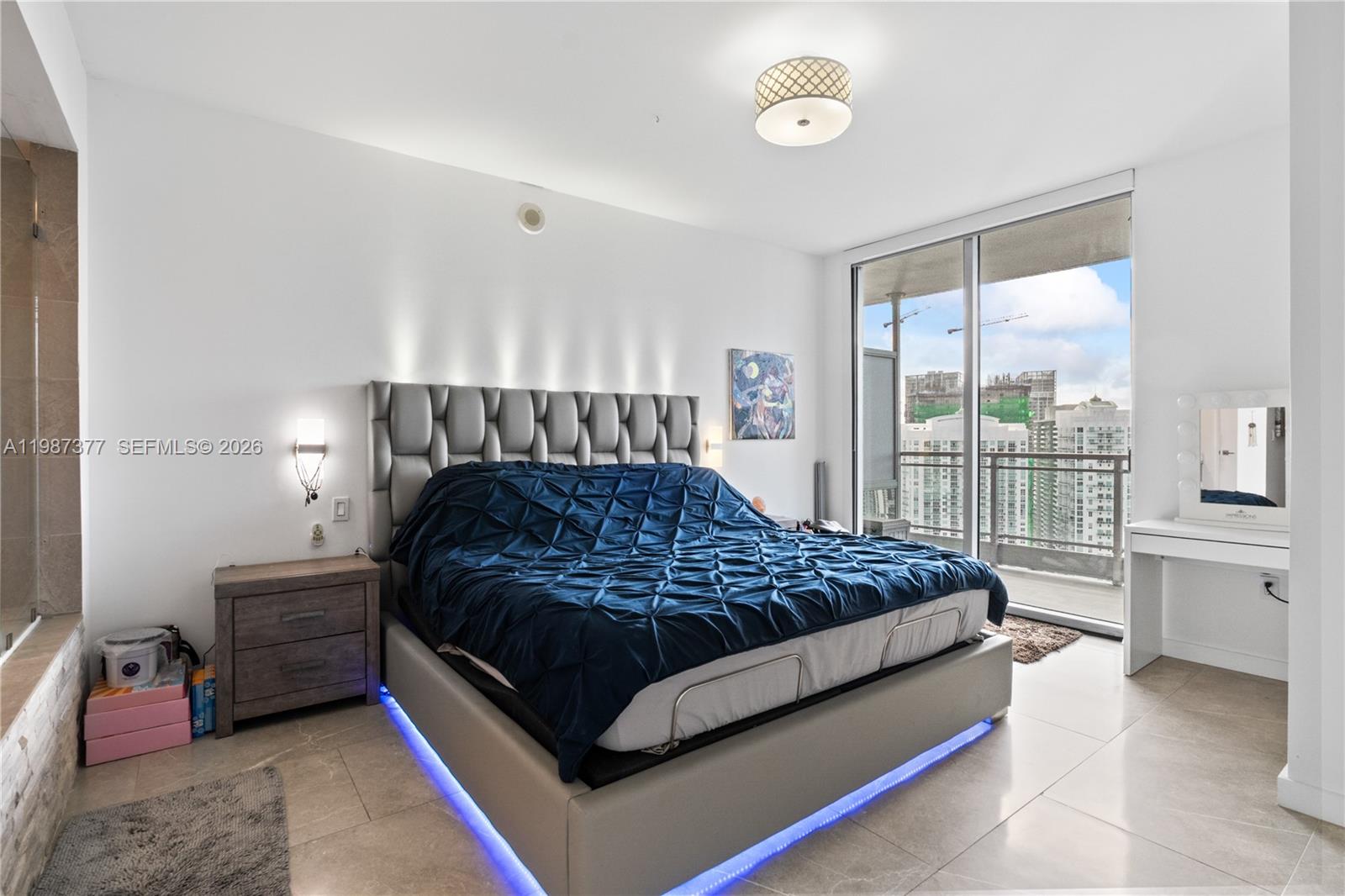 90 Southwest 3rd Street, Unit 4301 Miami, FL 33130 - Photo 9 of 18 a bedroom with a bed chair and a large window