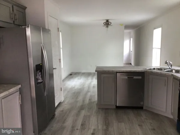a kitchen with granite countertop a refrigerator and a sink