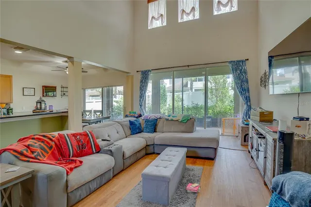 a view of a kitchen with kitchen island stainless steel appliances a sink and living room view
