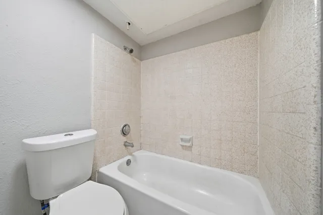 an empty room with window and ceiling fan