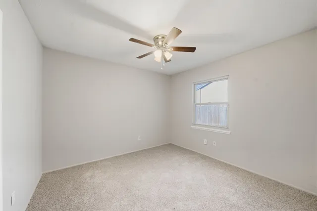 an empty room with a empty space and a ceiling fan