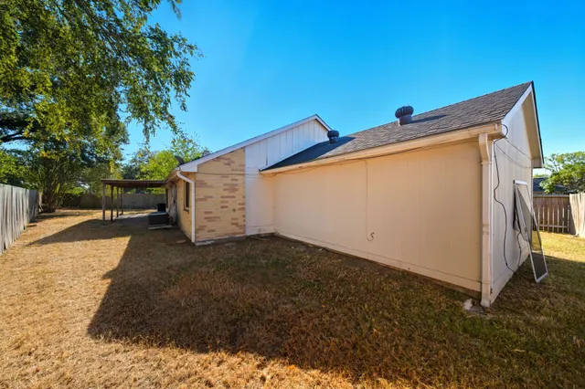 a backyard of a house with table and chairs