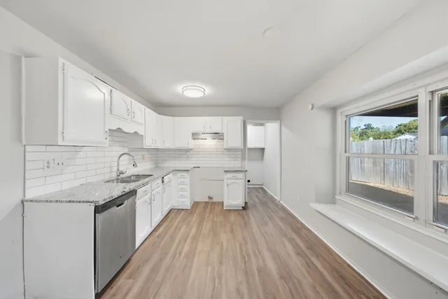a kitchen with granite countertop white cabinets and white appliances