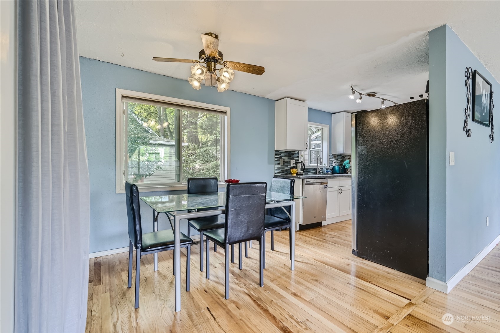 6935 24th Avenue Southwest Seattle, WA 98106 - Photo 6 of 27 a kitchen with a table chairs refrigerator and cabinets