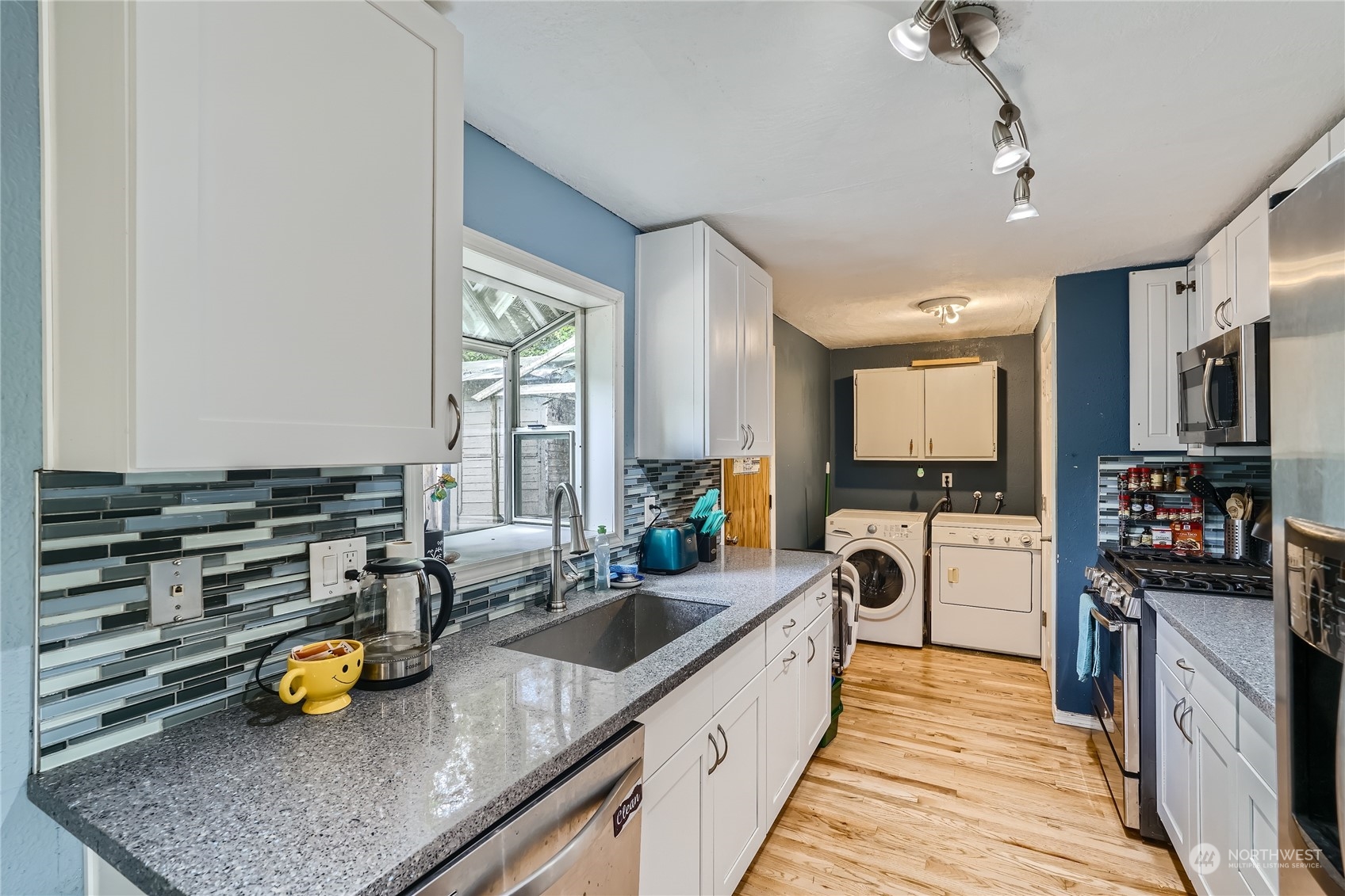6935 24th Avenue Southwest Seattle, WA 98106 - Photo 7 of 27 a kitchen with lots of counter top space and stainless steel appliances