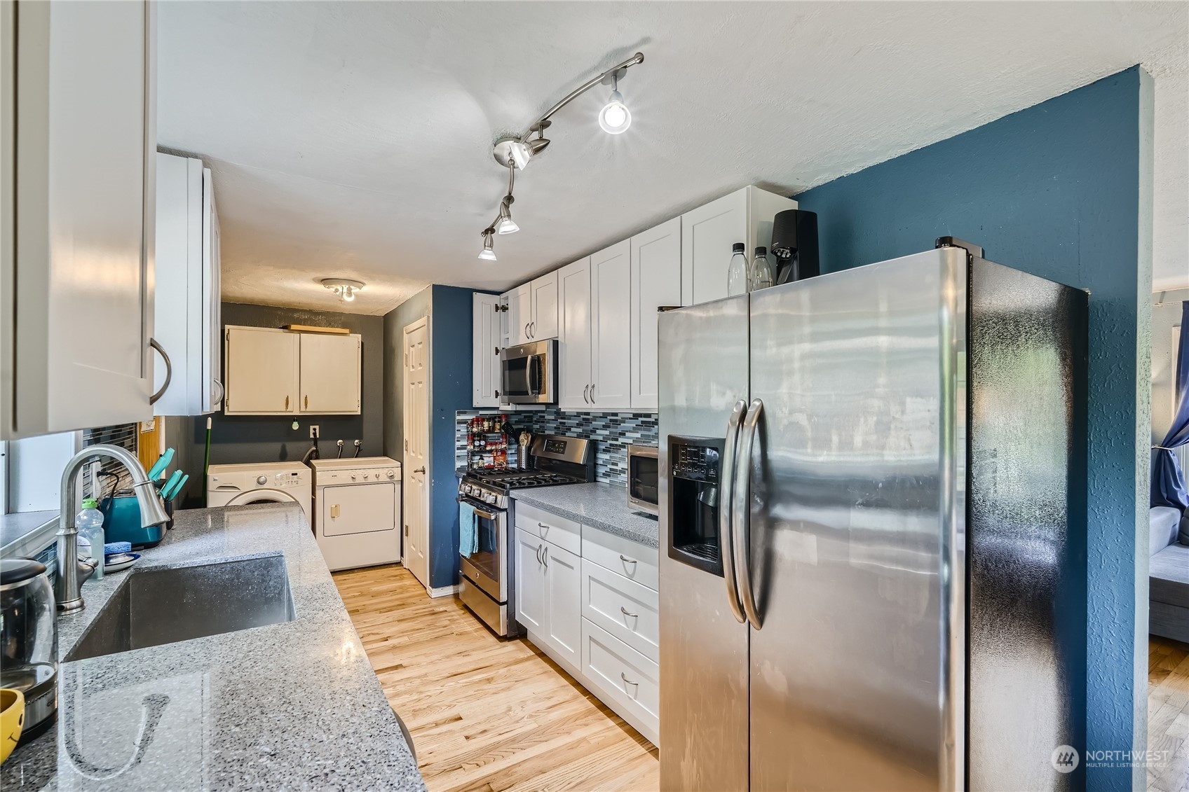 6935 24th Avenue Southwest Seattle, WA 98106 - Photo 8 of 27 a kitchen with stainless steel appliances a refrigerator sink and stove