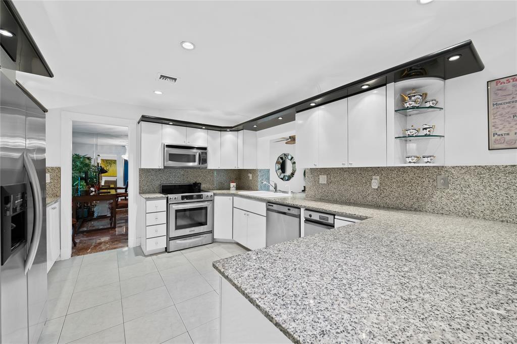 3301 Northeast 27th Avenue Lighthouse Point, FL 33064 - Photo 22 of 41 a kitchen with stainless steel appliances granite countertop a sink stove oven and refrigerator
