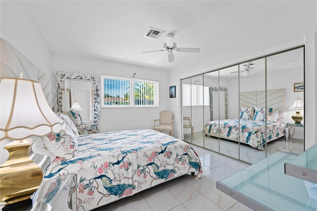 3301 Northeast 27th Avenue Lighthouse Point, FL 33064 - Photo 29 of 41 a bedroom with a large bed and a chandelier