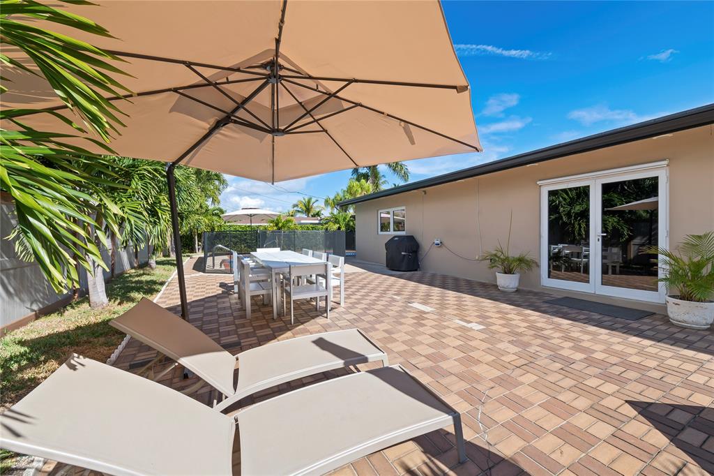 3301 Northeast 27th Avenue Lighthouse Point, FL 33064 - Photo 35 of 41 a view of a patio with a table and chairs under an umbrella