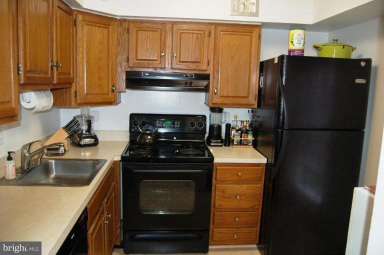 3230 Spartan Road, Unit 67 Olney, MD 20832 - Photo 6 of 11 a kitchen with stainless steel appliances granite countertop a refrigerator stove and sink