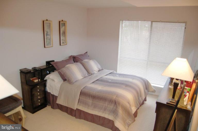 3230 Spartan Road, Unit 67 Olney, MD 20832 - Photo 7 of 11 a bedroom with a bed and a lamp
