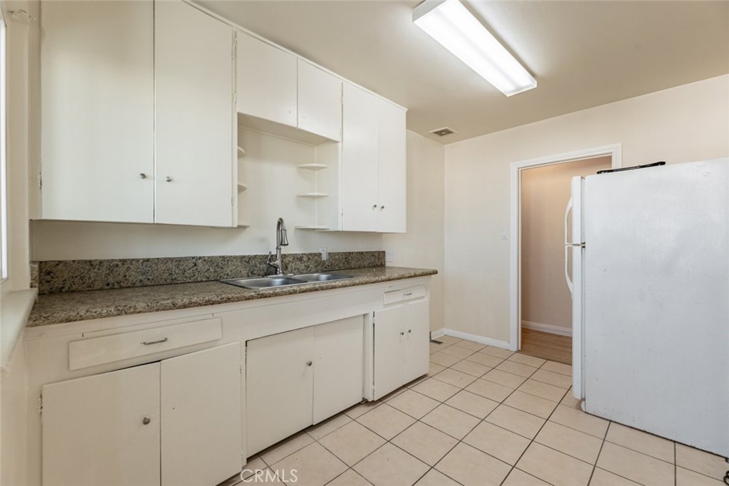 6623 San Fernando Road, Unit A Glendale, CA 91201 - Photo 17 of 33 a bathroom with a granite countertop sink and white cabinets