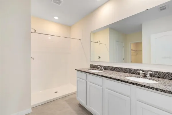 a bathroom with a granite countertop sink a toilet and shower