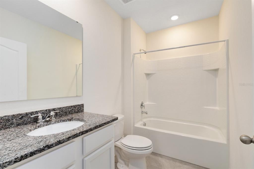 2520 Harmonia Hammock Road Harmony, FL 34773 - Photo 16 of 26 a bathroom with a granite countertop sink a toilet and shower