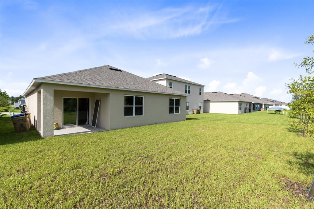 2520 Harmonia Hammock Road Harmony, FL 34773 - Photo 20 of 26 a front view of a house with yard and garage