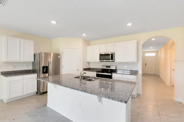 a kitchen with stainless steel appliances granite countertop a sink refrigerator and microwave