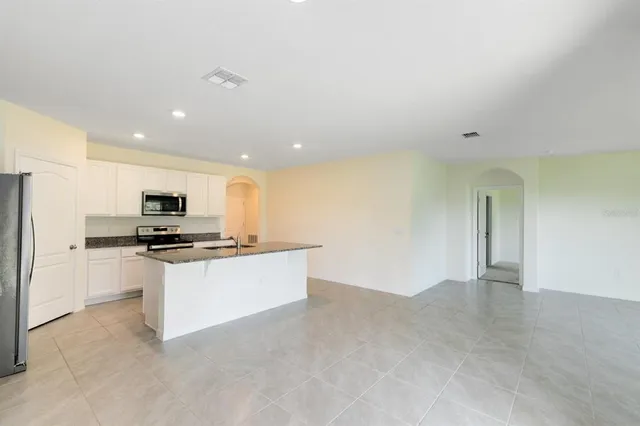 a view of kitchen with stainless steel appliances a refrigerator sink and stove
