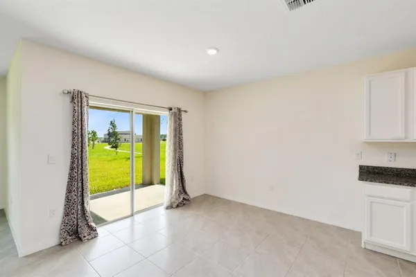 a view of empty room with kitchen view and window