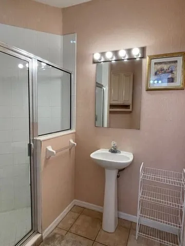 a bathroom with a sink mirror and a shower