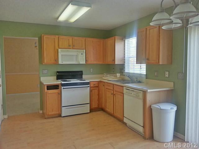 10546 Gold Pan Road Charlotte, NC 28215 - Photo 4 of 16 a kitchen with sink a microwave and cabinets
